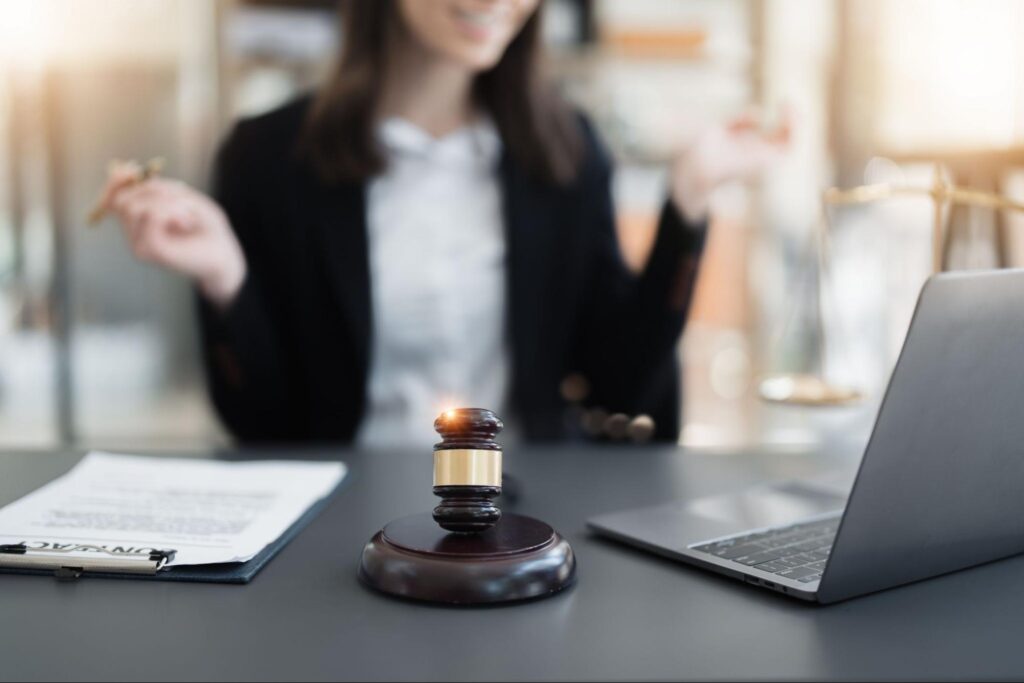 woman experiencing a hybrid courtroom proceeding on a computer and gavel